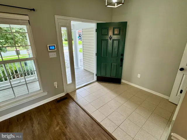 an entryway view with wooden floor and windows