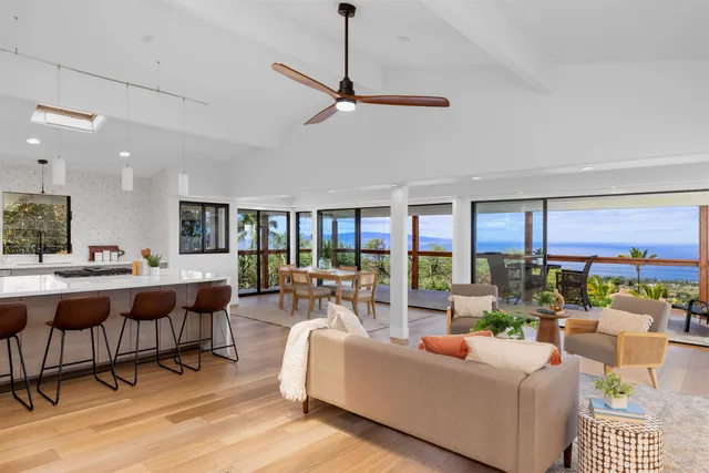 a living room with furniture a rug and a floor to ceiling window