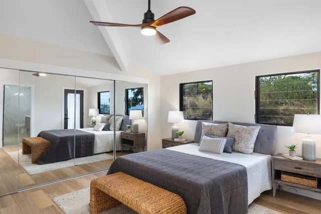 a bedroom with a bed a large window and couch