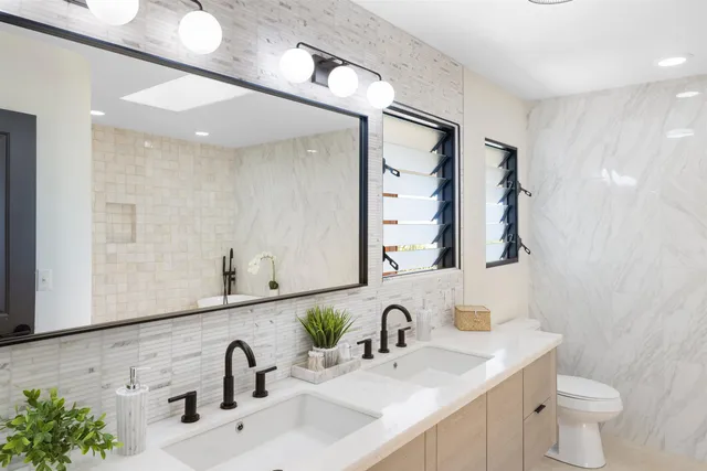a bathroom with a double vanity sink mirror and toilet