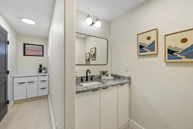 a bathroom with a granite countertop sink mirror and vanity