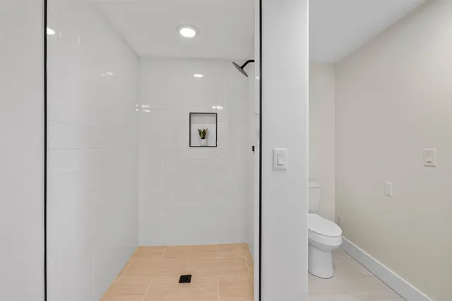 a bathroom with a shower a toilet and a shower