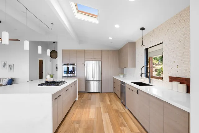 a large kitchen with kitchen island a sink stove and refrigerator