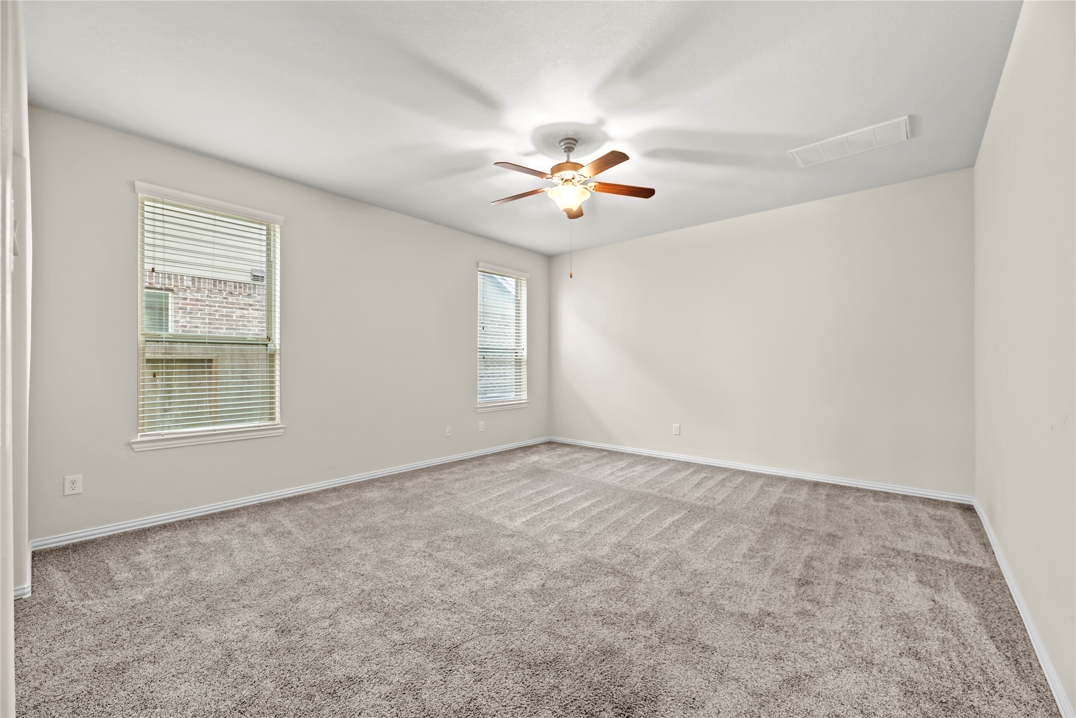 5205 Rainy Garden Court Rosharon, TX 77583 - Photo 14 of 43 an empty room with windows and chandelier fan