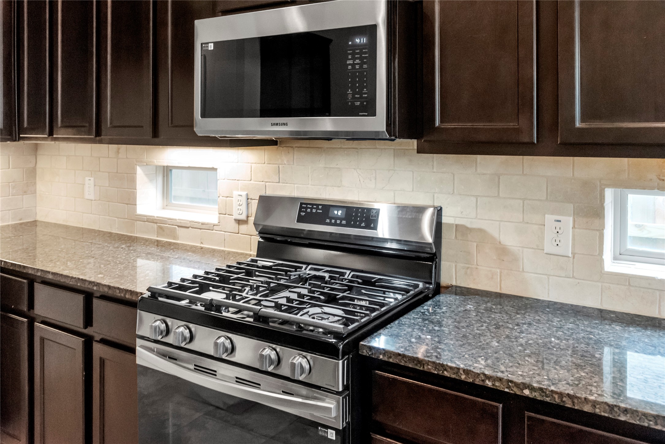 5205 Rainy Garden Court Rosharon, TX 77583 - Photo 5 of 43 a kitchen with stainless steel appliances granite countertop a stove and a microwave