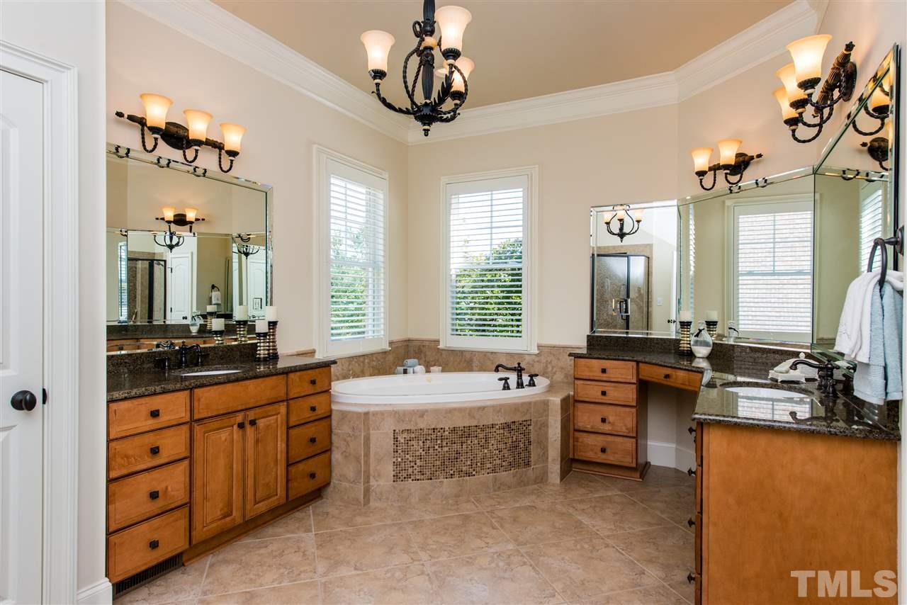 3003 Greyhawk Place Apex, NC 27539 - Photo 13 of 25 a large bedroom with a large bed and a chandelier