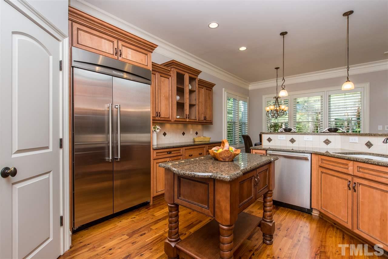 3003 Greyhawk Place Apex, NC 27539 - Photo 8 of 25 a kitchen with stainless steel appliances granite countertop a sink stove and refrigerator