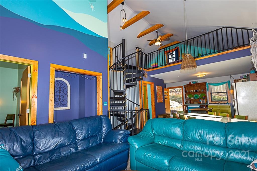 241 Ray Hill Road Horse Shoe, NC 28742 - Photo 11 of 43 a living room with furniture a ceiling fan and a book shelf
