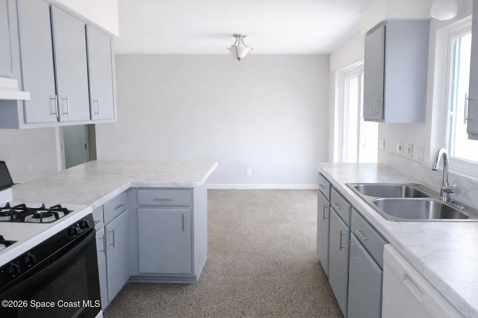 1336 Estridge Drive Rockledge, FL 32955 - Photo 5 of 11 a kitchen with granite countertop a sink stove and cabinets