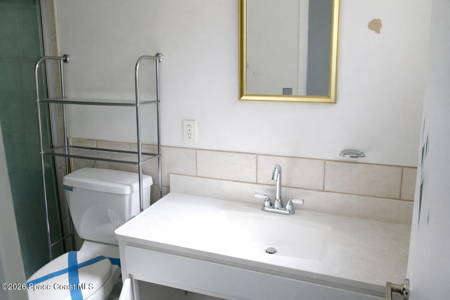 1336 Estridge Drive Rockledge, FL 32955 - Photo 8 of 11 a bathroom with a sink a toilet and mirror