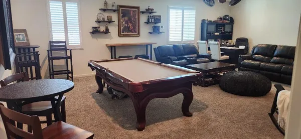 a living room with furniture a flat screen tv and a table