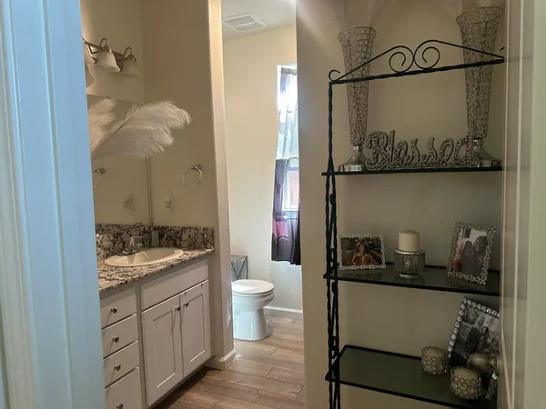 a bedroom with a bed potted plant on the dresser and a table