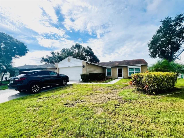 a view of house with yard and car parked
