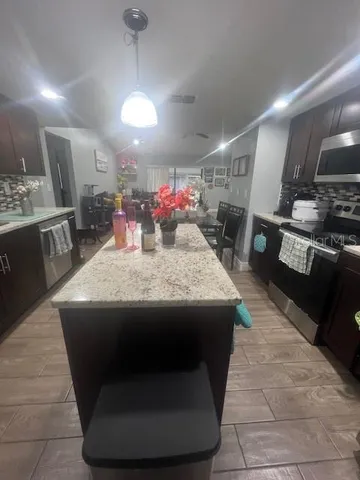 a kitchen with stainless steel appliances granite countertop a sink a stove and a refrigerator