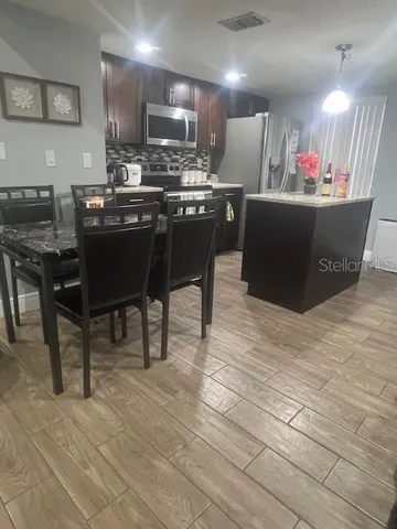 a kitchen with kitchen island granite countertop a sink cabinets and wooden floor