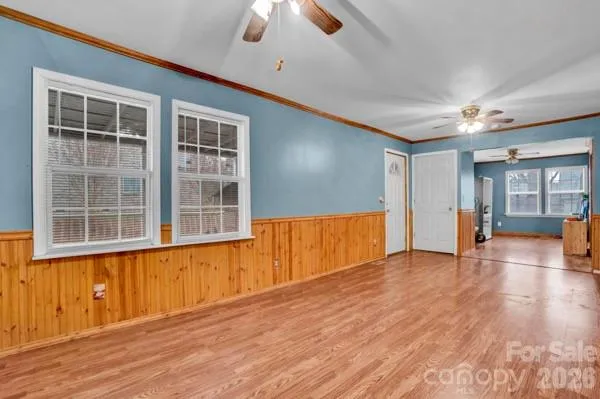 a view of empty room with a window and wooden floor