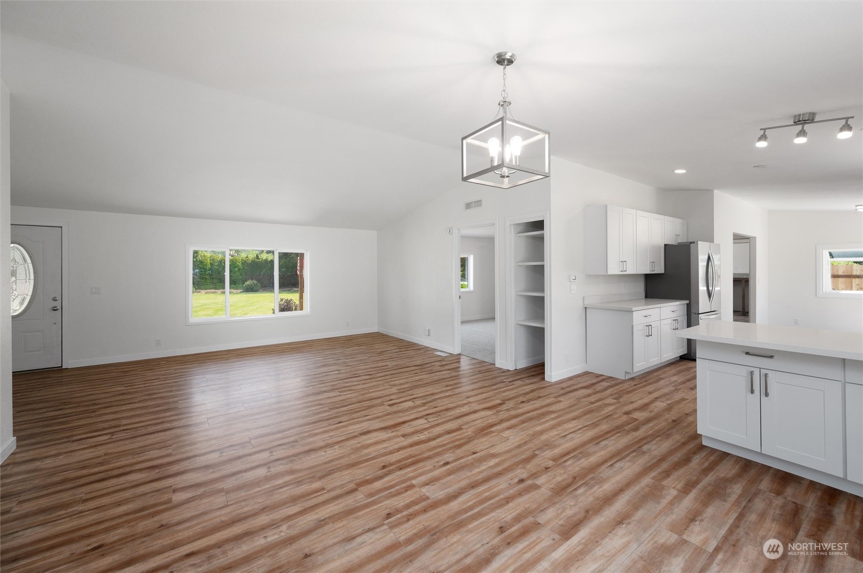 5805 Lawrence Road Everson, WA 98247 - Photo 32 of 35 an empty room with wooden floor and kitchen view