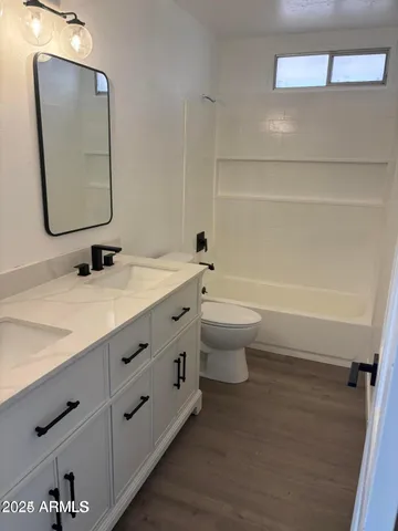 a bathroom with a toilet a sink a mirror and vanity