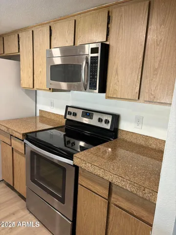 a kitchen with granite countertop a stove microwave and sink