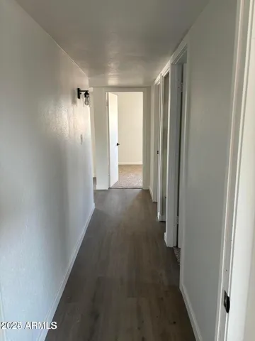 a view of a hallway with wooden floor