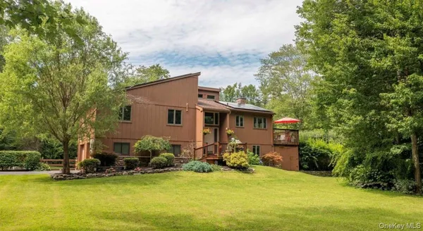 a view of a house with swimming pool next to a yard