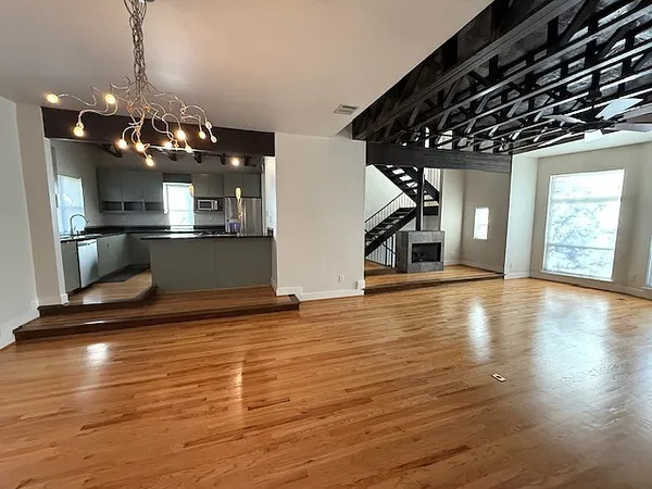 a view of a room with wooden floor and chandelier