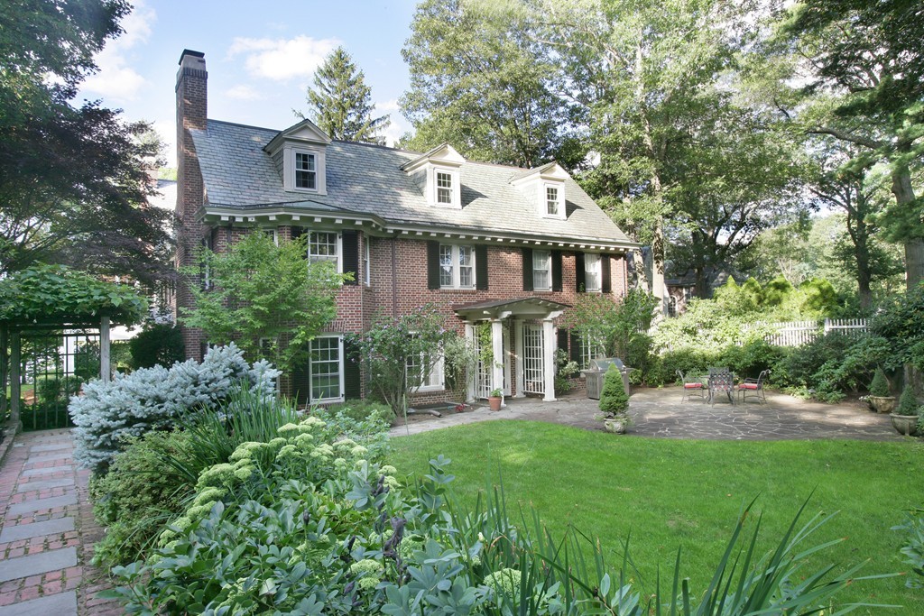 a view of a house with a yard and potted plants