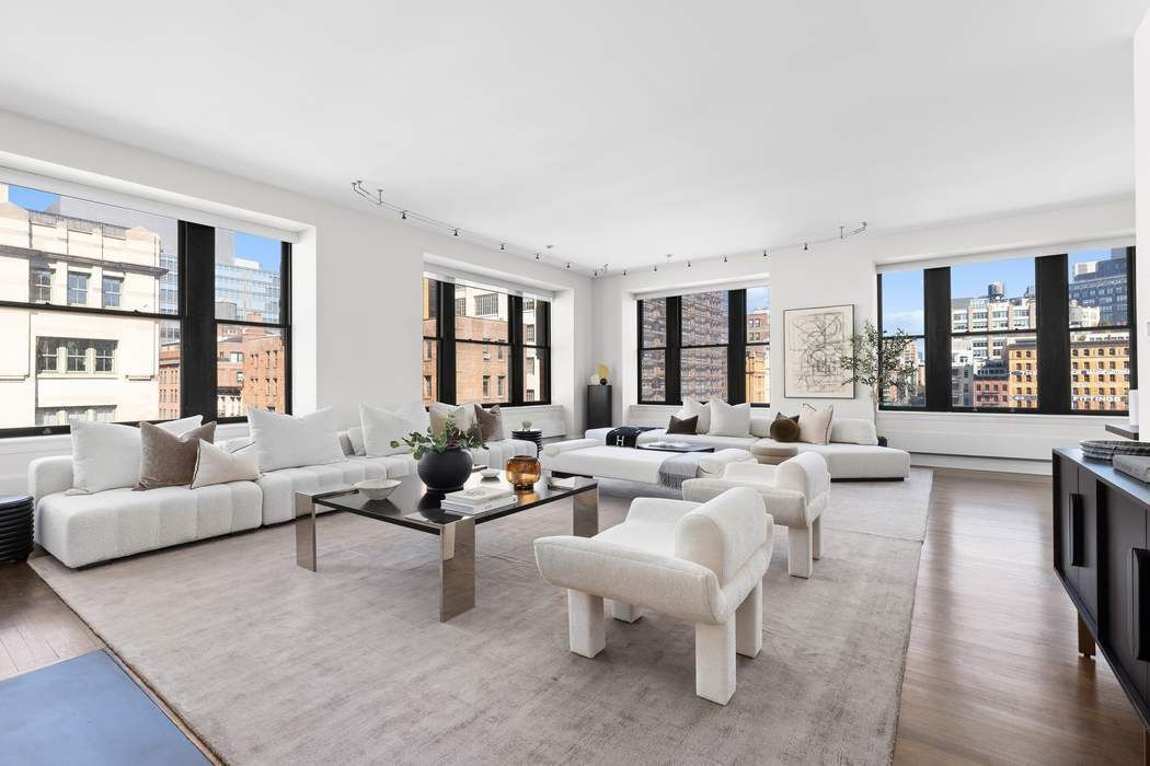 124 Hudson Street, Unit 5C Manhattan, NY 10013 - Photo 1 of 1 a living room with furniture and a large window