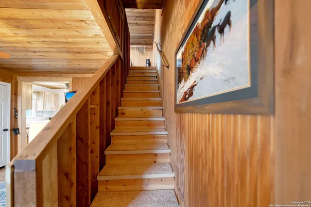 a view of staircase with wooden floor and white walls