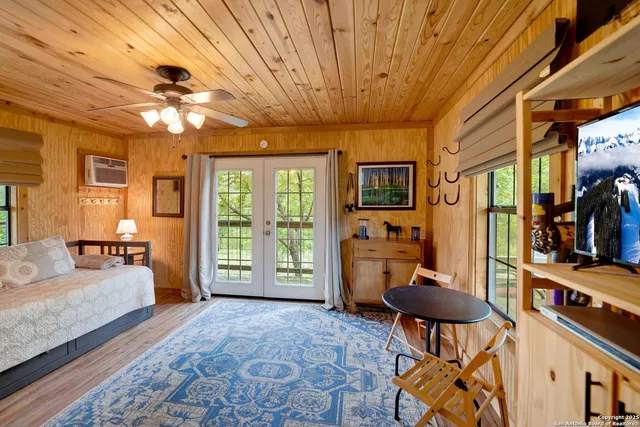 a living room with furniture a flat screen tv and a dining table