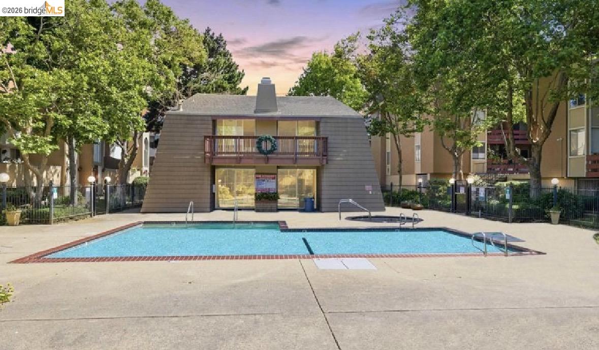 2121 Vale Road, Unit 50 San Pablo, CA 94806 - Photo 11 of 26 Outdoor pool and spa with surrounding concrete decking, complemented by a multi-story building featuring a second-level balcony