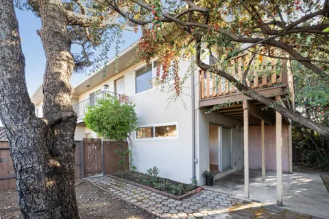 a view of a wooden house with a tree