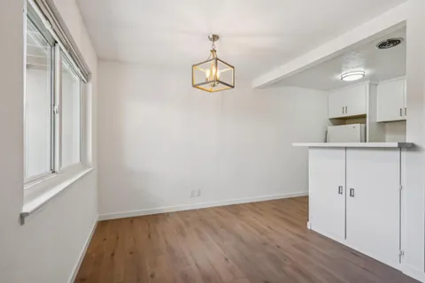 a view of a hallway with wooden floor and a window