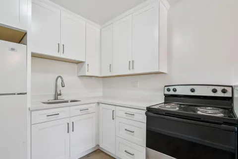 a kitchen with white cabinets and appliances