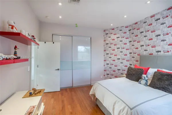 a large bed sitting in a bedroom next to a window