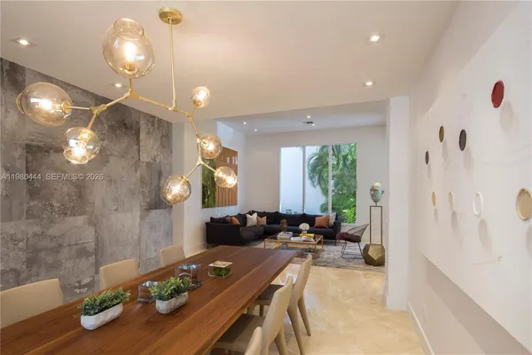 a room with stainless steel appliances kitchen island a table and chairs in it
