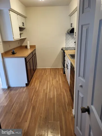 a kitchen with a sink and wooden floor