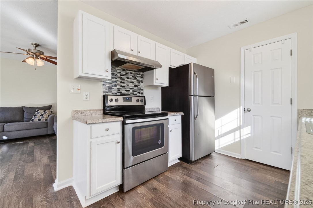 240 Rock Harbor Lane Spring Lake, NC 28390 - Photo 13 of 35 a kitchen with stainless steel appliances a stove a refrigerator and cabinets
