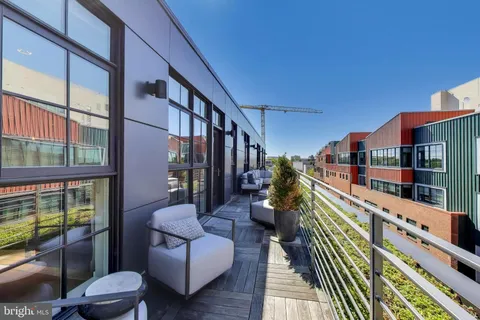 a balcony with couple of chairs and a couch