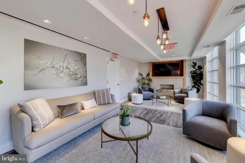 a living room with furniture a chandelier and a flat screen tv