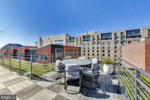 a roof deck with table and chairs