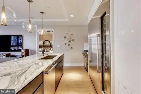 a kitchen with granite countertop a sink a counter top space stainless steel appliances and cabinets