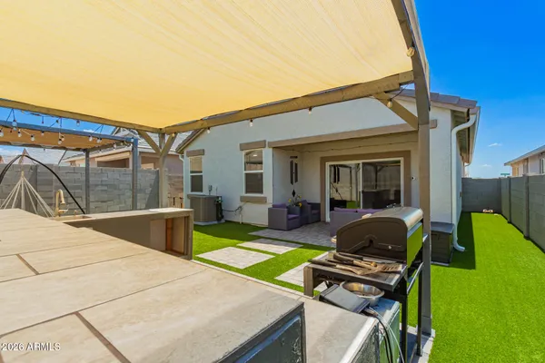 a view of backyard with outdoor seating and barbeque oven