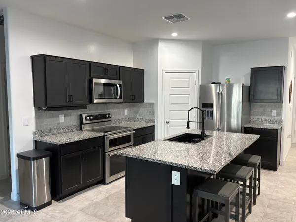 a kitchen with stainless steel appliances granite countertop a stove refrigerator and microwave