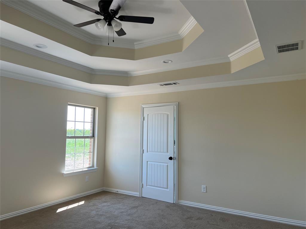 8008 County Road 1058 Rice, TX 75155 - Photo 11 of 25 Tray ceiling with crown molding and a ceiling fan