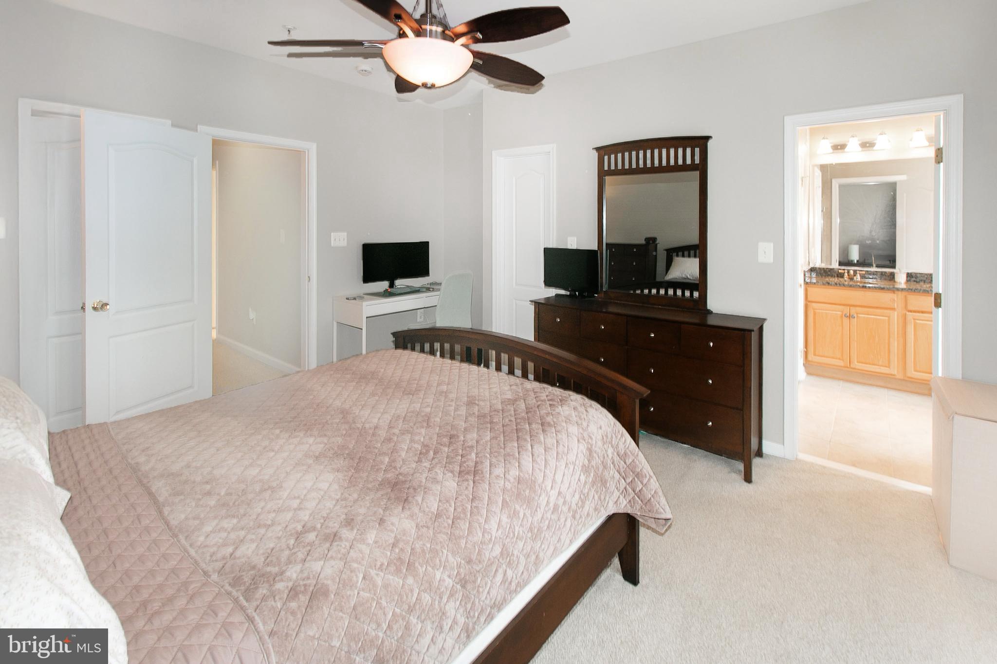 12426 Liberty Bridge Road Fairfax, VA 22033 - Photo 17 of 28 a bedroom with a bed and a flat tv screen on dresser