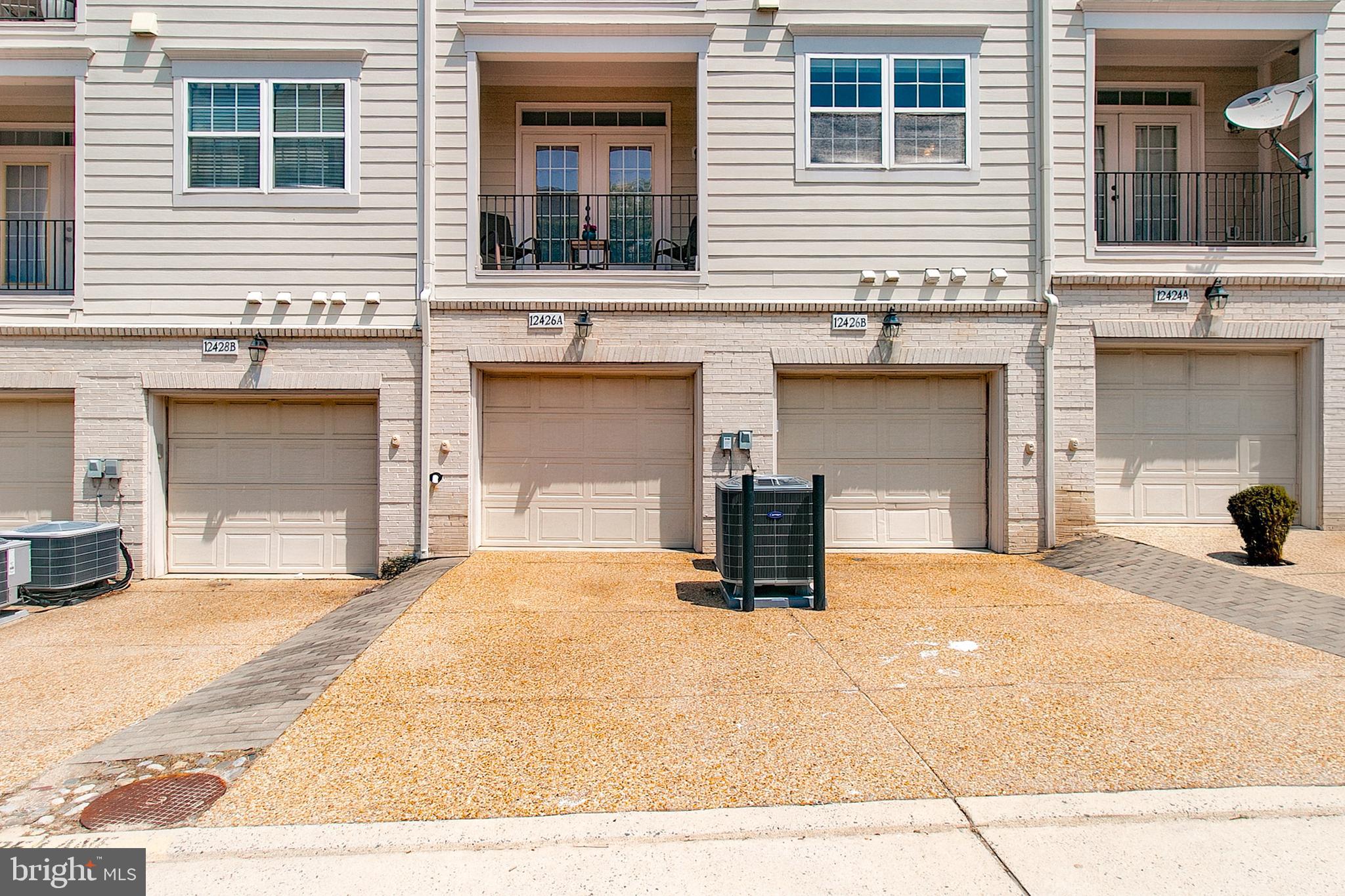 12426 Liberty Bridge Road Fairfax, VA 22033 - Photo 26 of 28 a view of a house with potted plants and a car parked front of it