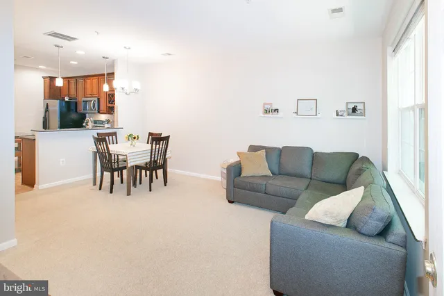 a living room with furniture and a dining table with kitchen view