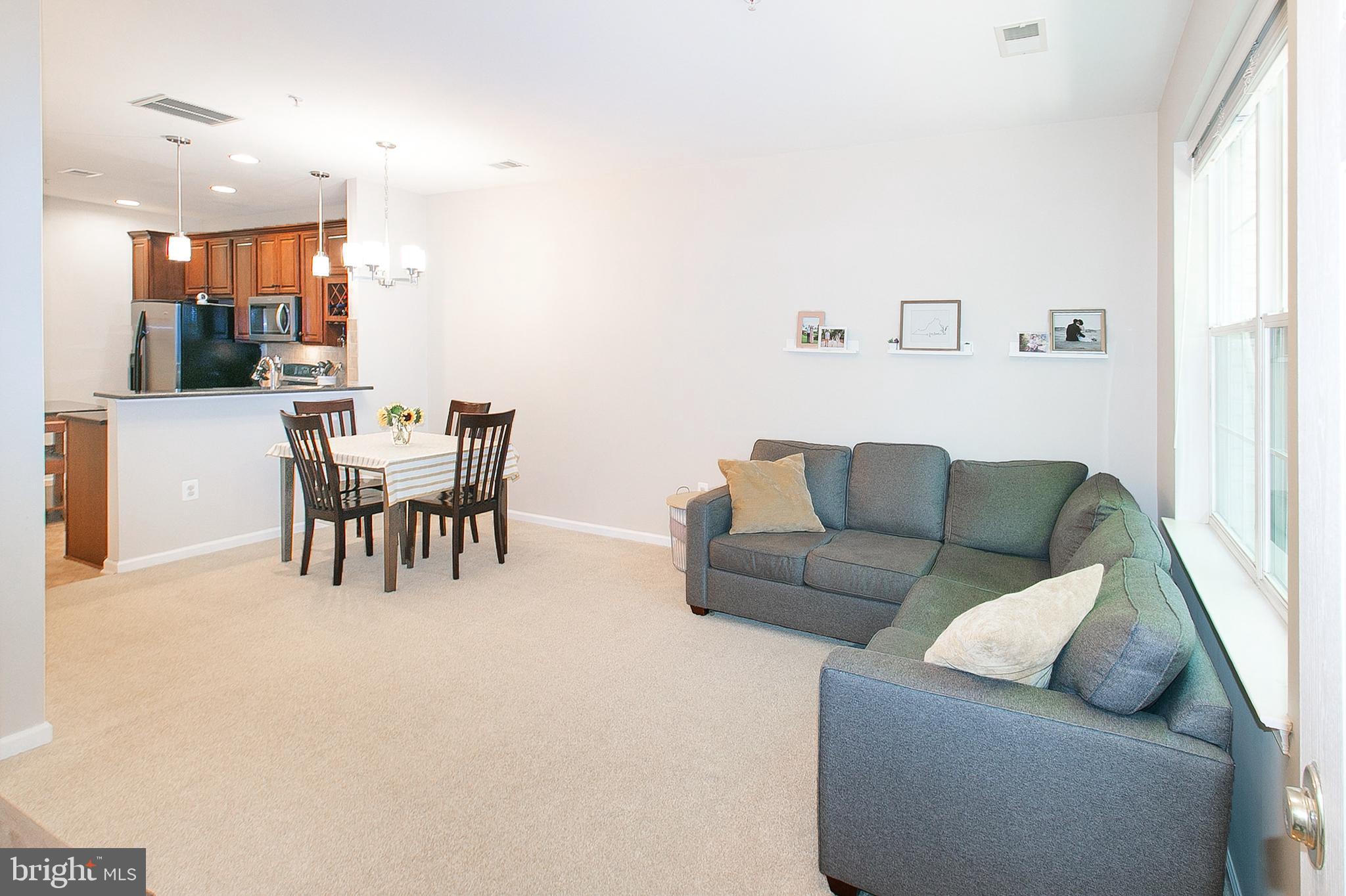 12426 Liberty Bridge Road Fairfax, VA 22033 - Photo 4 of 28 a living room with furniture and a dining table with kitchen view