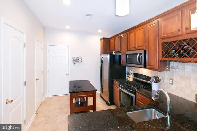 a kitchen with stainless steel appliances granite countertop a stove a sink and a refrigerator